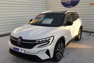 Renault Austral E-Tech Full Hybrid 200 Iconic blanc nacré avec toit noir, vue 3/4 avant droit, calandre et phares LED distinctifs.