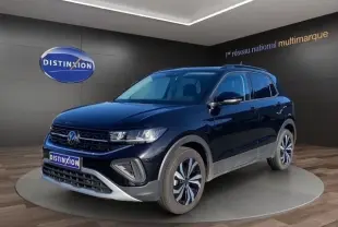 Vue 3/4 avant d'un Volkswagen T-Cross noir 2025, avec calandre noire et jantes alliage distinctives, en showroom.
