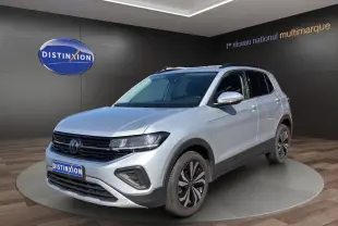 Volkswagen T-Cross gris clair en 3/4 avant droit, avec jantes alliage et calandre noire distinctive.