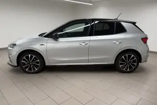 Vue de profil côté gauche d'une Skoda Fabia 2025 gris argent avec toit noir et jantes noires à motifs argentés.