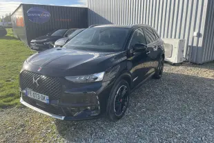 DS7 Crossback noir vue 3/4 avant droit, avec calandre distinctive et jantes noires brillantes sur gravier.