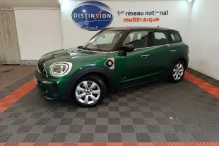 Vue de profil droit d'une MINI Countryman hybride rechargeable vert foncé avec toit noir en intérieur showroom.