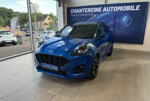 Ford Puma bleu en 3/4 avant droit dans un showroom avec calandre noire et jantes sport noires.