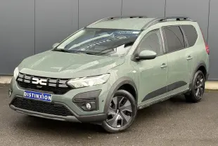 Dacia Jogger ECO-G 2025 en Kaki Lichen, vue 3/4 avant droit avec barres de toit et jantes spécifiques.