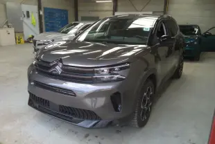 Citroën C5 Aircross gris platinium en 3/4 avant droit, SUV hybride essence avec signature lumineuse distinctive.