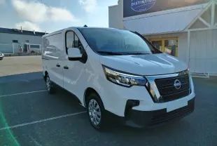 Vue 3/4 avant d'un utilitaire Nissan Primastar blanc 2025 avec calandre noire et pare-chocs noir mat, stationné en extérieur.