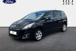 Vue 3/4 avant droit d'un Peugeot 5008 noir Perla Nera avec jantes alu et vitres arrière surteintées.