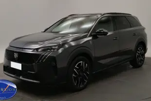Peugeot 5008 gris titane en 3/4 avant droit, avec jantes noires et phares LED allumés, en showroom.