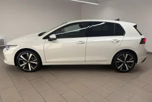 Vue de profil côté gauche d'une Volkswagen Golf 1.5 eTSI 116 BVM6 VW Edition blanche nacrée avec jantes alliage 18 pouces.