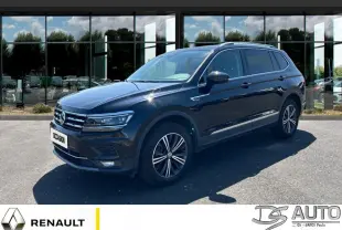 Volkswagen Tiguan Allspace noir vu de 3/4 avant droit, garé devant une vitrine réfléchissante.