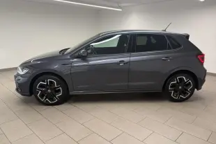 Volkswagen Polo 1.0 TSI R-Line gris cendré vue de profil côté gauche avec jantes alliage distinctives en intérieur blanc.