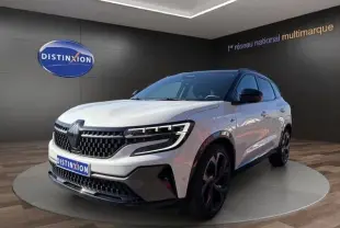 Vue 3/4 avant d’un Renault Austral blanc avec calandre noire et jantes noires dans un showroom.