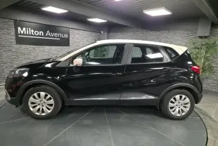 Profil côté gauche du Renault Captur noir avec toit et coques de rétroviseurs ivoire, jantes alliage 16 pouces visibles.