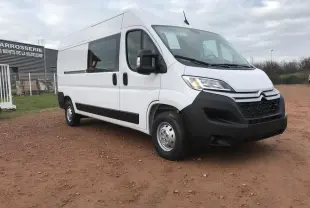 Fourgon Citroën Jumper blanc en vue 3/4 avant droit, avec porte latérale coulissante et pare-chocs noir mat.