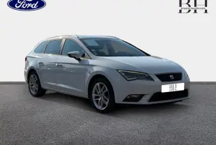 SEAT Leon ST gris étoile vue 3/4 avant droit, break compact avec jantes alliage et barres de toit visibles.