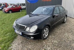 Mercedes Classe E 320 CDI noire vue en 3/4 avant droit, avec calandre chromée et phares ovales caractéristiques.