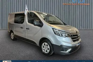 Renault Trafic Fourgon gris en 3/4 avant droit, avec vitres surteintées et calandre noire brillante.