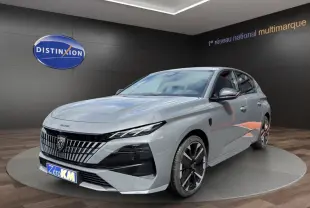 Peugeot 308 gris clair en vue 3/4 avant droit, avec calandre distinctive et jantes noires bicolores.
