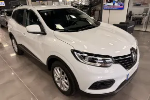 Renault Kadjar blanc Glacier en vue 3/4 avant droit, avec calandre noire et phares LED dans un showroom.
