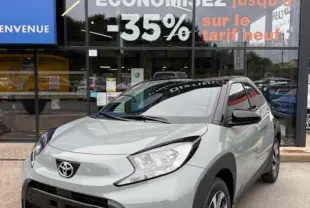 Toyota Aygo X 2025 vue 3/4 avant en couleur gris clair avec jantes alliage et détails noirs contrastants.