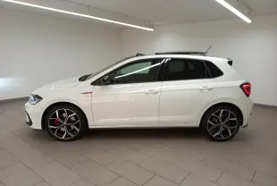 Vue de profil côté gauche d'une Volkswagen Polo GTI blanche avec toit ouvrant noir et jantes 18 pouces en alliage.