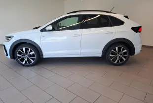 Vue de profil côté gauche du Volkswagen Taigo blanc pur 2025 avec jantes alliage noir et argent 18 pouces R-Line Edition.