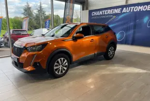 Peugeot 2008 orange vue de 3/4 avant droit en showroom avec jantes alliage et calandre noire distinctive.