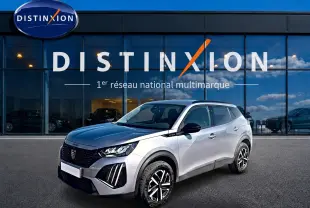 Peugeot 2008 gris 3/4 avant droit, avec calandre noire et jantes distinctives, devant showroom Distinxion.