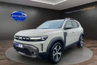 Dacia Duster beige en 3/4 avant droit, avec calandre distinctive et jantes alliage bicolores.