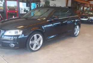 Audi A3 Cabriolet noir vue 3/4 avant droit avec capote fermée, jantes alliage et intérieur sombre en showroom.