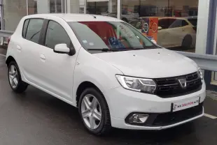 Dacia Sandero blanc glacier vue 3/4 avant droit, avec calandre noire et jantes alliage cinq branches.