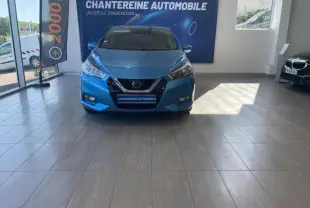 Vue frontale d'une Nissan Micra 2020 bleu électrique exposée en showroom avec logo Nissan visible sur la calandre.