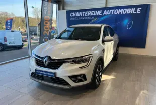 Renault Arkana blanc perle en 3/4 avant droit dans un showroom avec logo Chantreine Automobile en arrière-plan