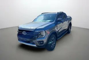 Ford Ranger gris carbone en 3/4 avant droit avec jantes alu 18 pouces et barres de toit visibles.