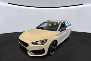 Vue 3/4 avant droite d'une CUPRA Leon ST blanche 2024 avec calandre noire et jantes noires en intérieur bois.