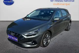 Vue 3/4 avant droit d'une Hyundai i30 gris argent 2024 avec jantes alliage et phares LED distinctifs.
