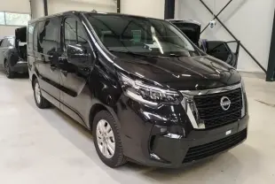 Nissan Primastar noir vue 3/4 avant droit, avec calandre chromée et phares LED dans un garage.
