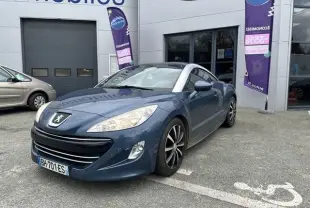 Peugeot RCZ bleu vue 3/4 avant droit, avec toit bombé argenté et jantes alliage distinctives.