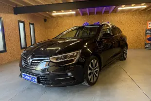 Renault Mégane Estate noir étoilé vue 3/4 avant droit dans un garage avec éclairage intérieur.