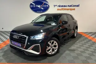 Audi Q2 noir métal vue 3/4 avant droit dans un showroom avec éclairage LED et jantes alliage.
