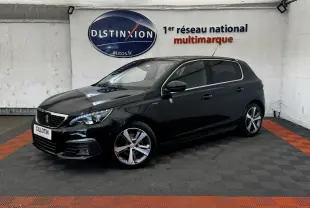 Peugeot 308 noir vue 3/4 avant droit dans un showroom avec jantes alliage et phares LED allumés.