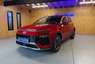 Vue 3/4 avant d'une Hyundai Bayon rouge avec calandre noir laqué et jantes alu 17 pouces dans un showroom.