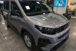 Peugeot Rifter gris acier en 3/4 avant droit, avec calandre noire et phares modernes, présenté en showroom.