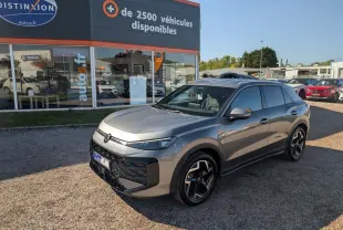 Volkswagen T-Roc gris métallisé vu en 3/4 avant droit, avec jantes 18 pouces et toit noir.