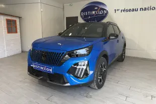 Peugeot 2008 GT bleu Vertigo métal avec toit noir, vue 3/4 avant droit en intérieur showroom.