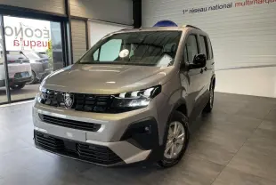 Peugeot Rifter gris Artense en 3/4 avant droit, avec calandre noire et jantes tôles 16 pouces en showroom.