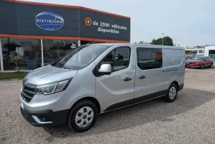 Renault Trafic Fourgon gris Highland en 3/4 avant droit, avec portes latérales vitrées et enjoliveurs 16 pouces.