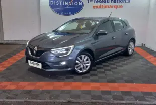 Renault Mégane Business TCe 115 gris foncé vue 3/4 avant droit, phares LED allumés en intérieur showroom.