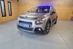 Citroën C3 gris 2019 vue 3/4 avant droit en intérieur avec jantes alu et rétroviseurs noirs électriques.