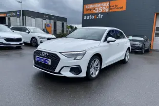 Audi A3 Sportback blanc Ibis vue 3/4 avant droit avec calandre noire et jantes alliage 18 pouces sur parking humide